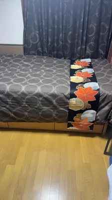 a bed in a room with a black couch at \u8fa3\u6912\u6c11\u5bbf in Tokyo