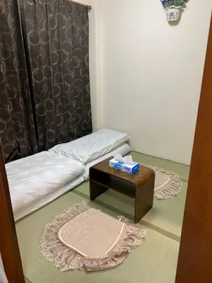 a small room with a bed and a table at \u8fa3\u6912\u6c11\u5bbf in Tokyo