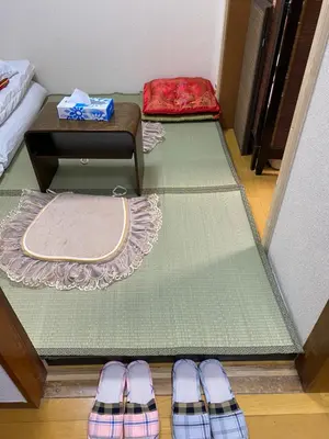 a room with mats and a table and a pair of shoes at \u8fa3\u6912\u6c11\u5bbf in Tokyo