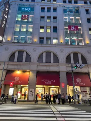 a large building with people walking in front of it at \u8fa3\u6912\u6c11\u5bbf in Tokyo