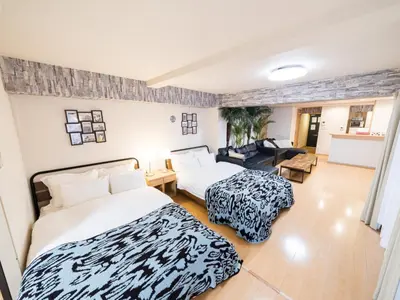 a bedroom with two beds and a living room at Shinjuku, 1min walk from Kagurazaka Sta,80sqm,Family-Friendly, in Tokyo