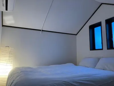 a white bedroom with a bed and two windows at \u30eb\u30fc\u30c1\u30a7\u897f\u65b0\u5bbf in Tokyo