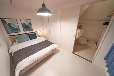 a bedroom with a bed and a walk in closet at FINOA Residential Suite Horikiri in Tokyo