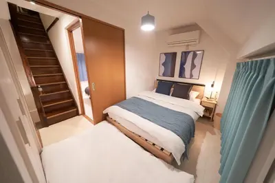a small bedroom with a bed and a staircase at FINOA Residential Suite Horikiri in Tokyo