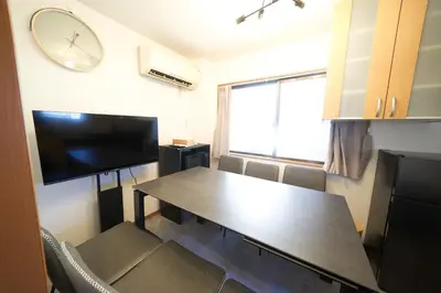 a dining room with a table and a clock on the wall at FINOA Residential Suite Horikiri in Tokyo