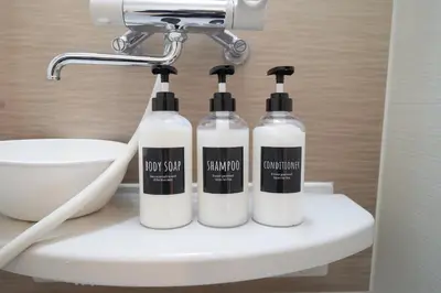 three bottles of soap sitting on top of a sink at FINOA Residential Suite Horikiri in Tokyo