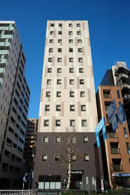 a tall building with a tree in front of it at Nplus HOTEL Tokyo Nihonbashi in Tokyo