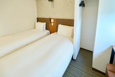 two beds in a small room with white sheets at Nplus HOTEL Tokyo Nihonbashi in Tokyo
