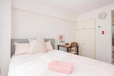 a bedroom with a white bed with a pink towel on it at \u65b0\u5bbf\u533a\u6b4c\u821e\u4f0e\u753a\u8212\u9002\u623f\u6e90\u514d\u8d39Wi-Fi#03 in Tokyo