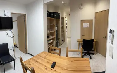 a room with a table and chairs and a television at \u6d45\u8349\u685c\u6a4b\u30cf\u30a6\u30b9-Asakusa Sakurabashi House- in Tokyo