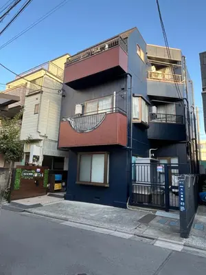 a blue building with balconies on a city street at Cozy inn Oyama 101 in Tokyo
