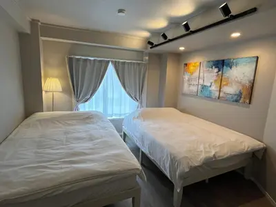 a bedroom with two beds and a window at Cozy inn Oyama 101 in Tokyo