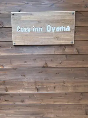 a sign on a wooden wall with the words cozy im ozone at Cozy inn Oyama 101 in Tokyo