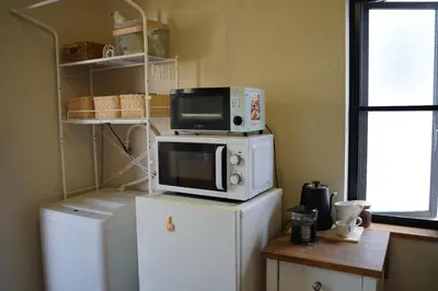 a kitchen with a microwave on top of a refrigerator at Shimokitazawa Akima in Tokyo