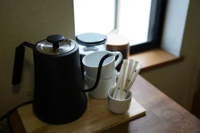 a table with a coffee pot and cups on it at Shimokitazawa Akima in Tokyo
