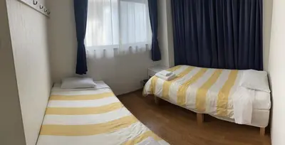 a small room with two beds and a window at \u6d45\u8349\u685c\u6a4b\u30cf\u30a4\u30c4 Asakusa Sakurabashi\u3000 2F in Tokyo