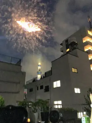 a fire show in the sky above a building at \u6d45\u8349\u685c\u6a4b\u30cf\u30a4\u30c4 Asakusa Sakurabashi\u3000 2F in Tokyo