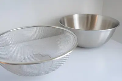 a strainer and a metal bowl on a table at unito residence HIGASHISHINJUKU in Tokyo