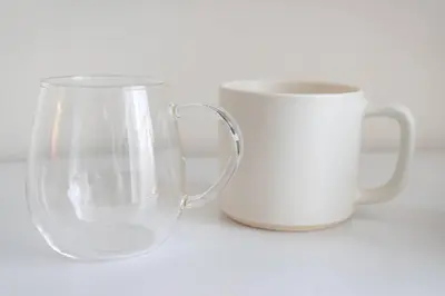 two white coffee mugs sitting next to each other at unito residence HIGASHISHINJUKU in Tokyo