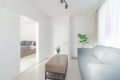 a white living room with a couch and a table at unito residence WASEDA in Tokyo