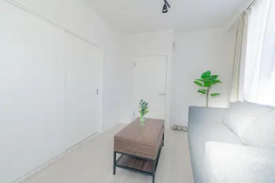 a living room with a couch and a coffee table at unito residence WASEDA in Tokyo
