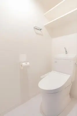 a white bathroom with a toilet and a roll of toilet paper at unito residence OTSUKA in Tokyo