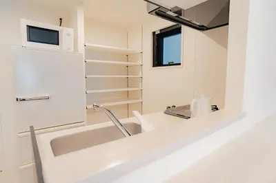 a white bathroom with a sink and a mirror at unito residence OTSUKA in Tokyo