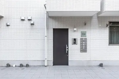 a black door on a white brick building at Felice Nishi-Shinjuku in Tokyo