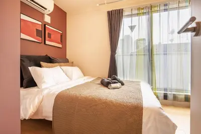 a bedroom with a bed and a large window at Felice Nishi-Shinjuku in Tokyo