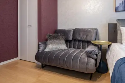 a leather couch sitting in a room next to a bed at Felice Nishi-Shinjuku in Tokyo