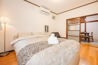 a bedroom with a bed and a table with a chair at Himawari in Tokyo