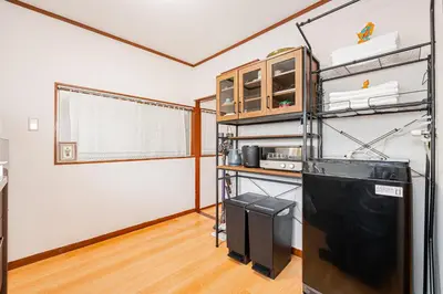 a room with a kitchen with a shelf and a door at Himawari in Tokyo
