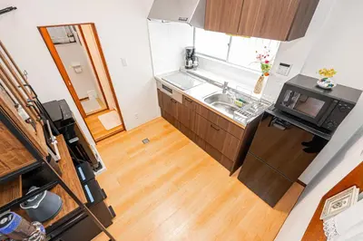 a small kitchen with a sink and a wooden floor at Himawari in Tokyo