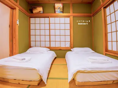 two beds in a room with two windows at 7\u6642IN19\u6642OUT # \u6c60\u888b\u738b\u5b50\u8d64\u7fbd\u99c5\u7121\u6599\u9001\u8fce # \u4e0a\u91ce\u99c514\u5206 # \u4e00\u68df\u8cb8\u3057 # 2LDK2LDK # \u6700\u592724\u4eba # 7 00 IN19 00 OUT # Free pick-up at Ikebukuro, Oji, and Akabane Stations # 14 min to Ueno # Whole house rental # 2LDK2LDK # Max 24 in Tokyo