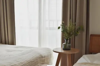 a vase of flowers on a table next to a window at \u30d7\u30ea\u30cd\u30c3\u30c4\u65b0\u5bbf\u30d3\u30eb3\u968e in Tokyo