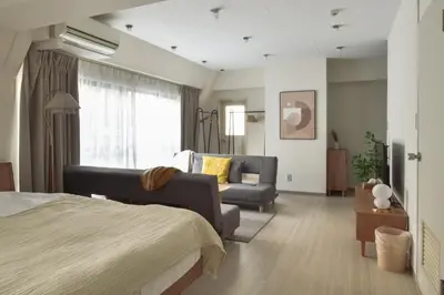 a bedroom with a bed and a couch and a chair at \u30d7\u30ea\u30cd\u30c3\u30c4\u65b0\u5bbf\u30d3\u30eb3\u968e in Tokyo