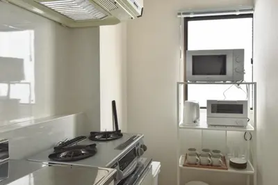 a kitchen with a stove and a microwave at \u30d7\u30ea\u30cd\u30c3\u30c4\u65b0\u5bbf\u30d3\u30eb3\u968e in Tokyo