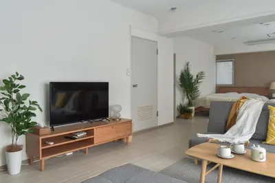 a living room with a flat screen tv on a wooden entertainment center at \u30d7\u30ea\u30cd\u30c3\u30c4\u65b0\u5bbf\u30d3\u30eb3\u968e in Tokyo