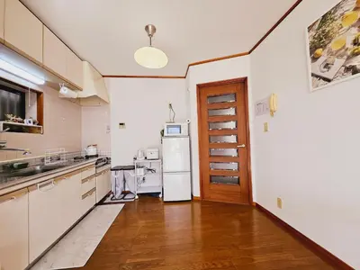a kitchen with a refrigerator and a wooden floor at AsahiStay -Koiwa, Free parking O, Whole Family House, Japanese garden taste in Tokyo