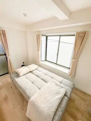 a large bed in a room with a large window at \u30b2\u30b9\u30c8\u30eb\u30fc\u30e0\u4e0a\u91ce\u685c\u6728(\u4e0a\u91ce\u99c5and\u65e5\u66ae\u91cc\u99c5) in Tokyo