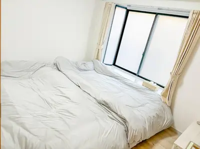 a white bed in a room with a window at \u30b2\u30b9\u30c8\u30eb\u30fc\u30e0\u4e0a\u91ce\u685c\u6728(\u4e0a\u91ce\u99c5and\u65e5\u66ae\u91cc\u99c5) in Tokyo