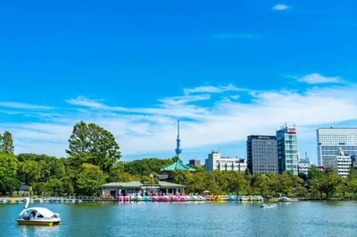 a boat on a river with a city in the background at \u30b2\u30b9\u30c8\u30eb\u30fc\u30e0\u4e0a\u91ce\u685c\u6728(\u4e0a\u91ce\u99c5and\u65e5\u66ae\u91cc\u99c5) in Tokyo