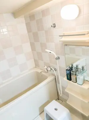 a bathroom with a white tub and a toilet at \u30b2\u30b9\u30c8\u30eb\u30fc\u30e0\u4e0a\u91ce\u685c\u6728(\u4e0a\u91ce\u99c5and\u65e5\u66ae\u91cc\u99c5) in Tokyo