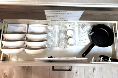 a cabinet filled with white dishes and utensils at \u30b2\u30b9\u30c8\u30eb\u30fc\u30e0\u4e0a\u91ce\u685c\u6728(\u4e0a\u91ce\u99c5and\u65e5\u66ae\u91cc\u99c5) in Tokyo