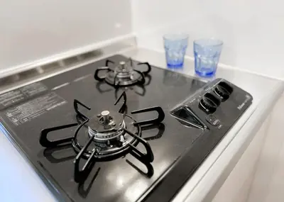 a stove top with a cat on top of it at The Bonsai Otsuka 202, Fresh Parkside Private Apartment in Central Tokyo in Tokyo