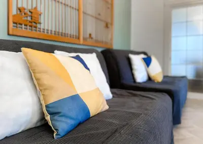 a couch with pillows on it in a living room at The Bonsai Otsuka 202, Fresh Parkside Private Apartment in Central Tokyo in Tokyo