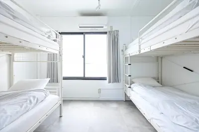 two bunk beds in a white room with a window at Eden House Skytree & Skygarden in Tokyo