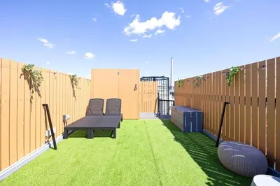 a patio with two chairs and a bench on the grass at Eden House Skytree & Skygarden in Tokyo