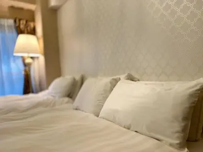 a bed with white sheets and pillows in a room at Fuufu House Tokyo Ikebukuro in Tokyo
