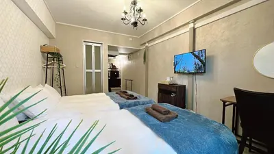 a bedroom with two beds and a flat screen tv at Fuufu House Tokyo Ikebukuro in Tokyo